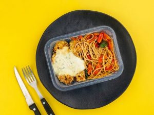 Frango empanado acompanhado de molho gorgonzola e macarrão com tomate cereja e manjericão