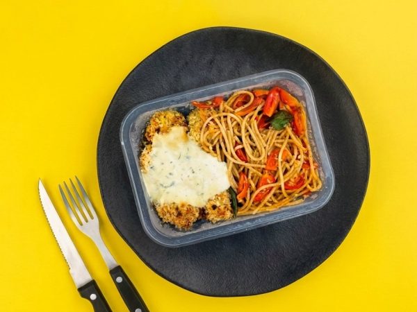 Frango empanado acompanhado de molho gorgonzola e macarrão com tomate cereja e manjericão